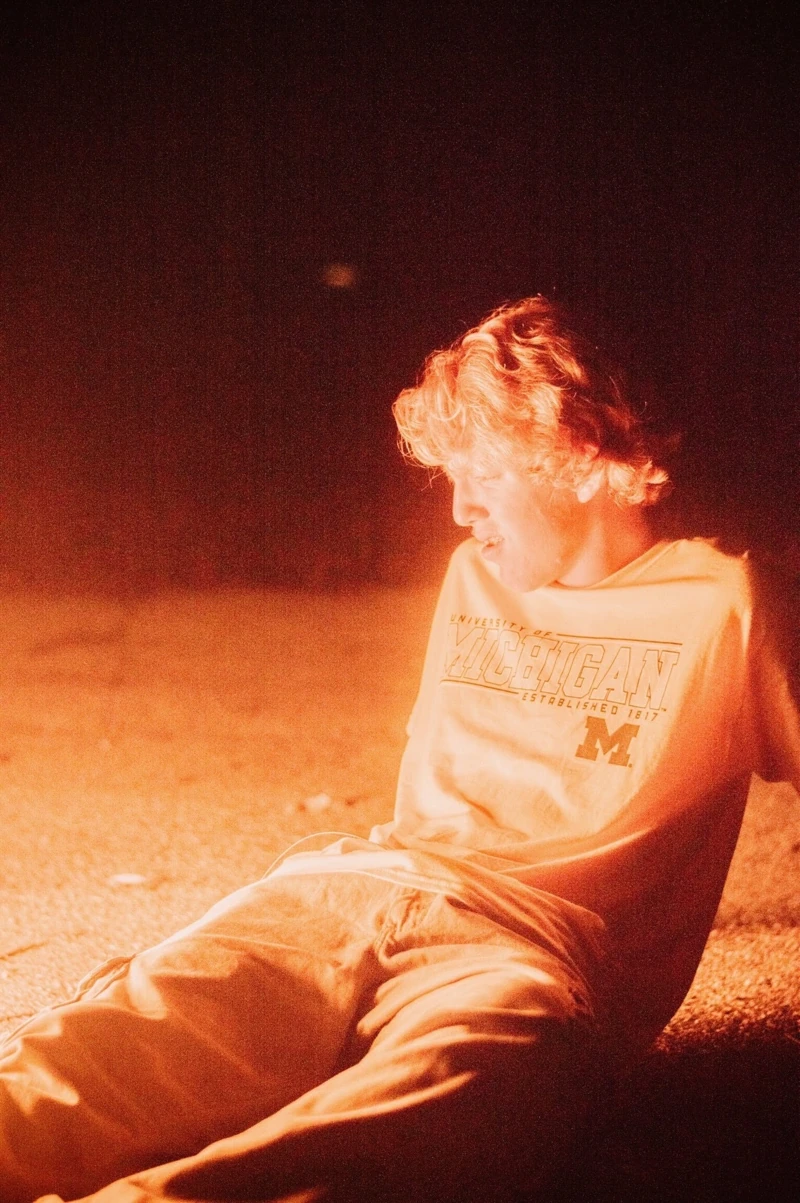 Seated portrait in warm orange light at night
